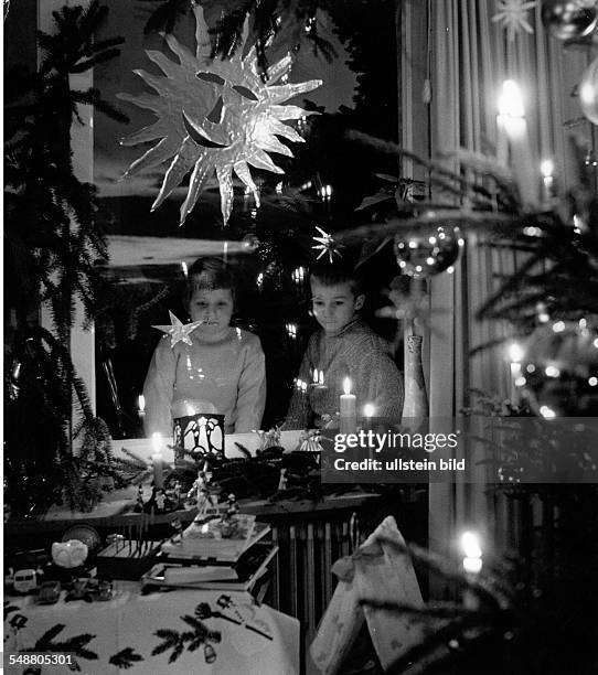 Germany; children looking throug the window on Christmas Eve