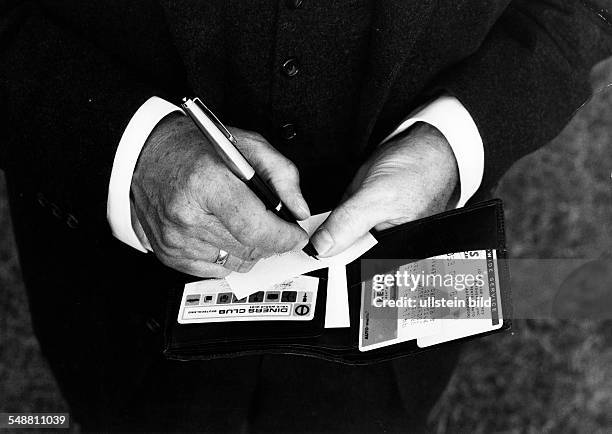 Man holding his wallet in his hands - 1969 - Photographer: Jochen Blume - Vintage property of ullstein bild