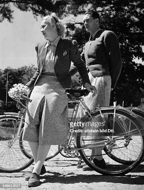 Man and woman wearing matching clothes for riding a bicycle - undated - Photographer: Gyula H. Brassai - Published by: 'Die Dame' 13/1938 Vintage...