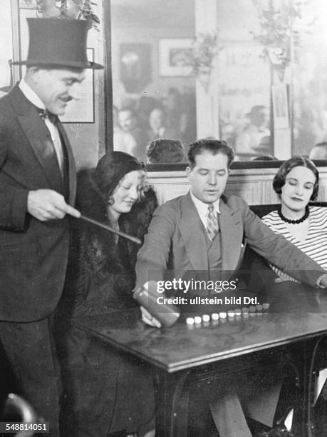 Ile de France Paris: Cabarett 'Jimmy' in Paris: the host of a small bar on the Montmarte entertaining his guests with legerdemains - 1931 -...