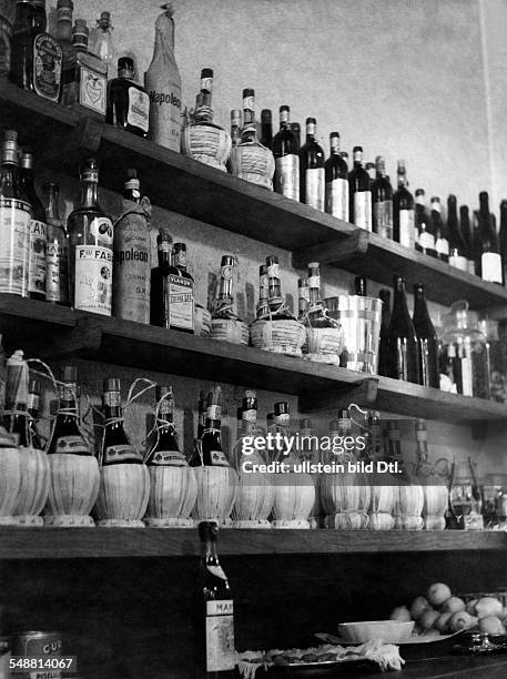 Italy, Emilia-Romagna, Bologna: Shelf with bottles of wine at the restaurant 'Pappagallo' - 1939 - Photographer: Hedda Walther - Published by: 'Die...