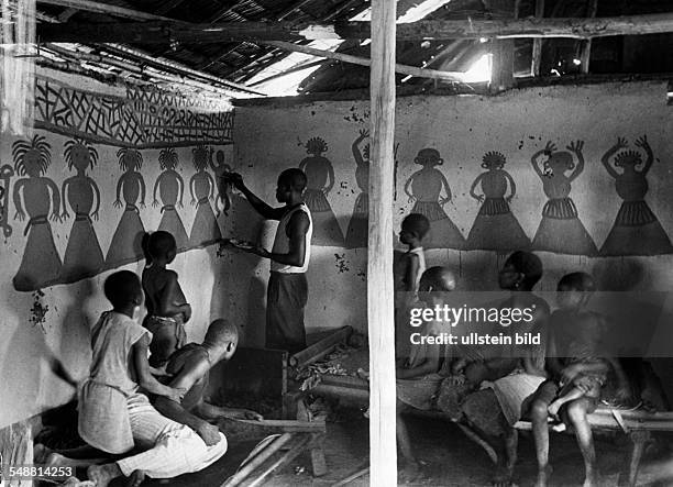 African artist painting the walls of cottage - ca 1938 - undated - Photographer: Erich Andres - Published by: 'Berliner Illustrirte Zeitung' 12/1938...