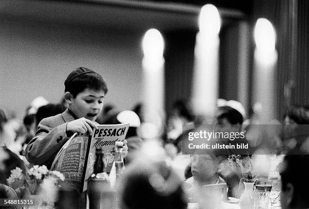 Federal Republic of Germany Bavaria Munich: Jewish Community, Children celebrating Pesach, a boy reading Haggadah of Pessach - - Photographer: Jochen...