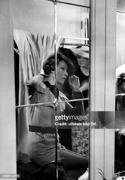 Great Britain England London: Fashion, in the dressing room during the German fashion show at the Mayfair Hotel, a model adjusting her hat - 1935 -...