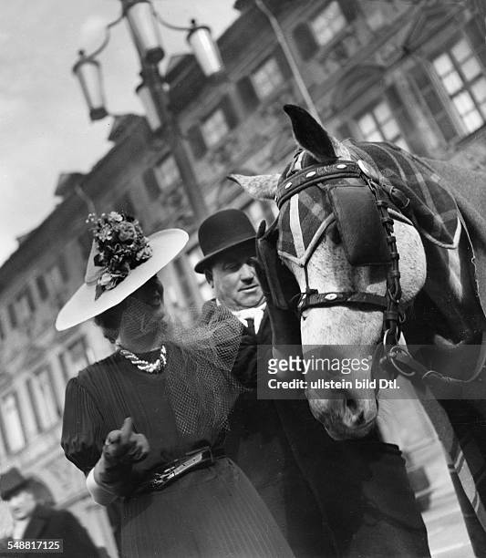 Italy : A lady with a hat stroking a horse with blinders - 1939 - Photographer: Sonja Georgi - Published by: 'Die Dame' 10/1939 Vintage property of...