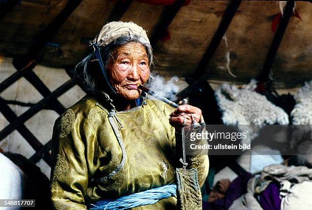Mongolia, one of the last old shaman in the province of Khoevsgoel smoking her traditional pipe.