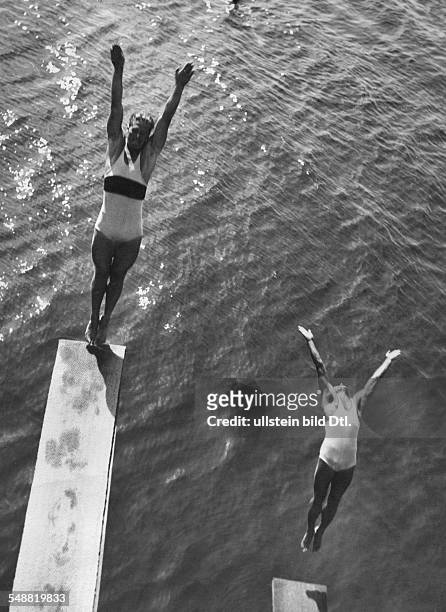Two swimmers jumping from towers into the water - um 1932 - Photographer: Abramovici - Published by: 'Der Querschnitt' 6/1932 Vintage property of...