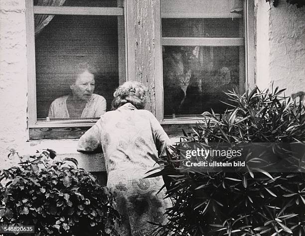 Florida, Miami:Two old women converse through the screens at a hotel on Collins Avenue in Miami Beach.