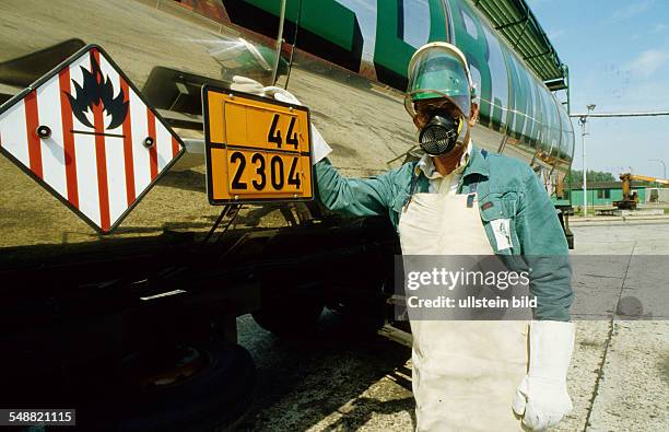 Germany, Traffic: Hazardous material driver with protective clothing to unload naphtalin. -