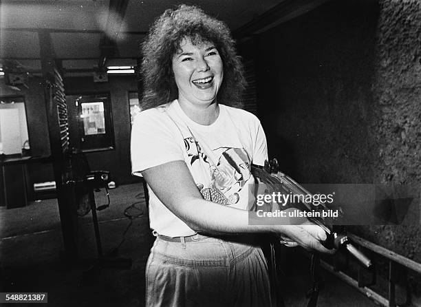 Georgia, Marietta: An American woman with a machine gun in the gun shop Bullett Stop. In Georgia its allowed to buy automatic guns