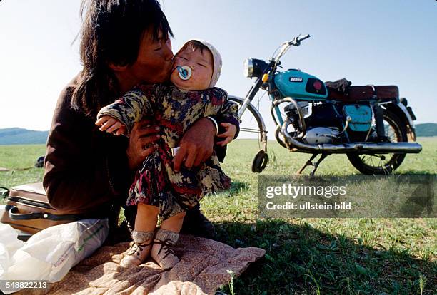 Mongolia, motorcycle break down on the way from Moeroen and Khatgal. Mother and child waiting for a near wheel.