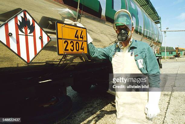Germany: A truck driver transporting hazardous materials wearing protective clothing for unloading Naphtalin.