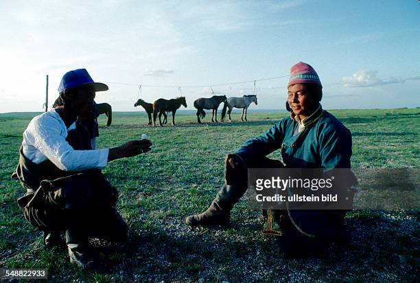 Mongolia, two friends exchanging snuff bottles. Gobi steppe, Oevoer-Hangay province.