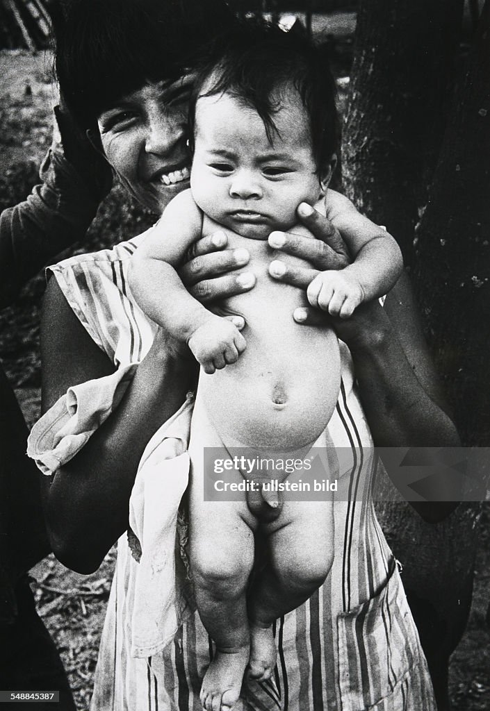 Ecuador - Jivaro woman displaying her baby in the Amazonas