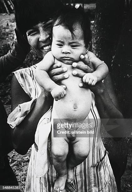 Ecuador - Jivaro woman displaying her baby in the Amazonas