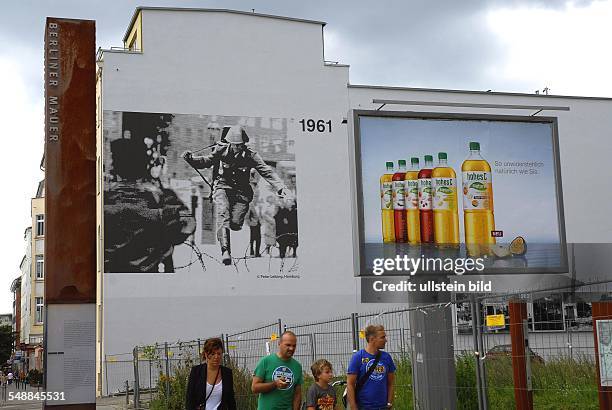 Germany Berlin Mitte - Path at the former Berlin Wall at Bernauer Strasse corner Brunnenstrasse, giant photo showing the escaping GDR border guard...