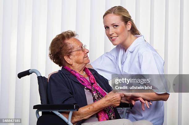 Nurse, doctor and elder lady in a wheel chair -