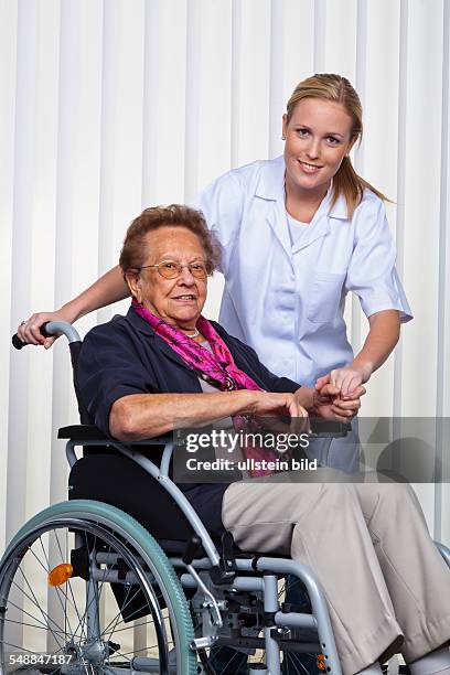 Nurse, doctor and elder lady in a wheel chair -