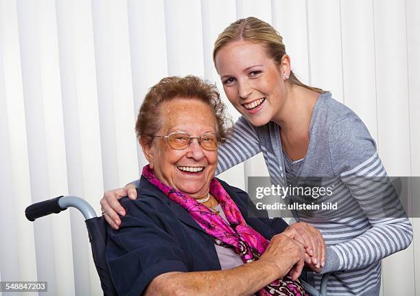 Young woman an d elder lady in a wheel chair -