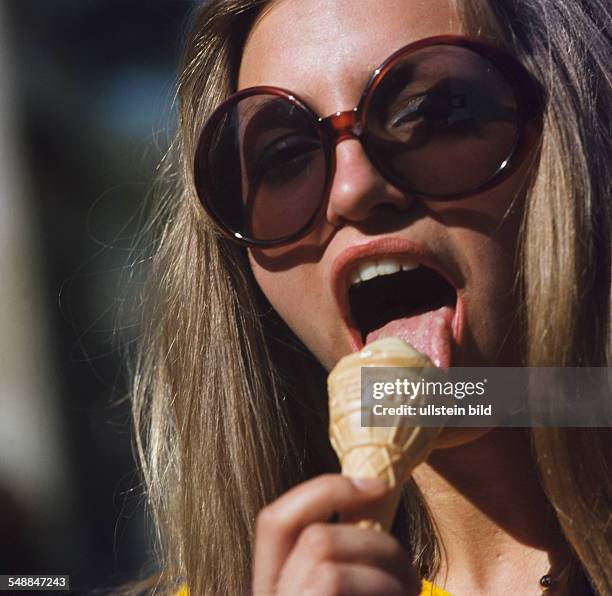 Woman with big sunglasses is eating ice cream - 1970s