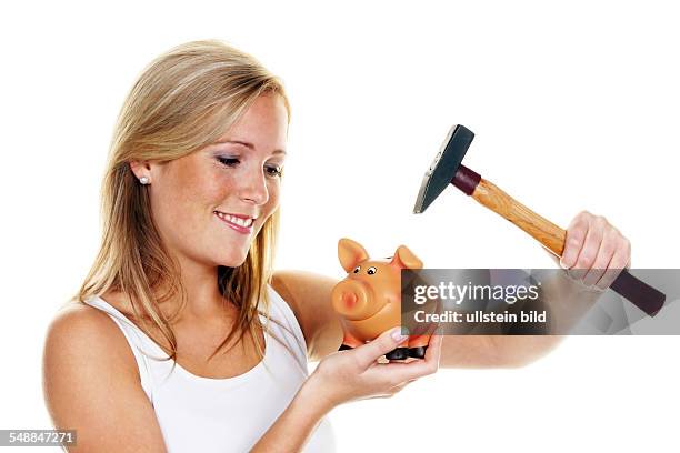 Symbolic photo robbing the piggy bank, woman with piggy bank and hammer -