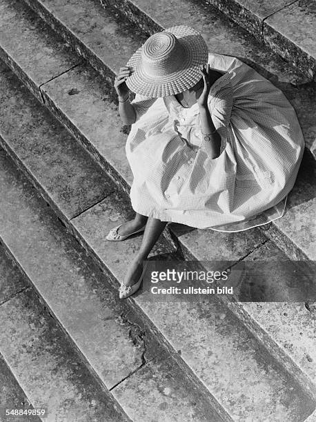 Germany Bavaria - woman with sun hat is sitting on the stairs - 1950s