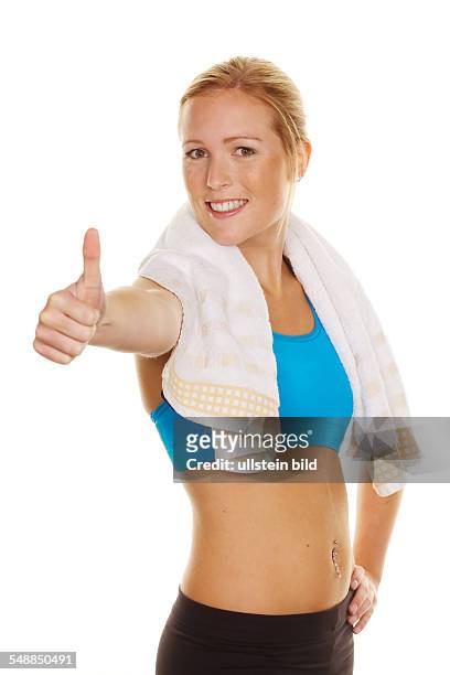 Fitness, young woman after working out with towel over her shoulders -