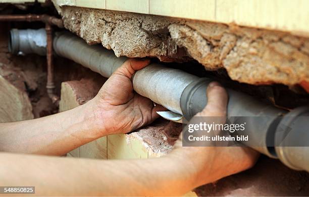 Installer installing a sewage pipe