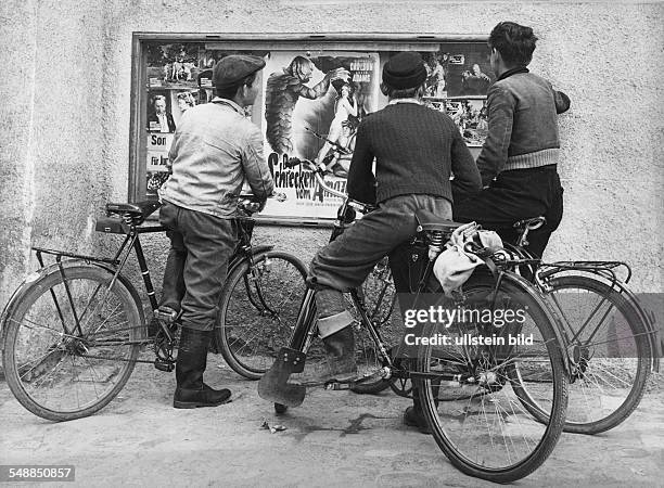 Germany - young men with bycicles watching film posters