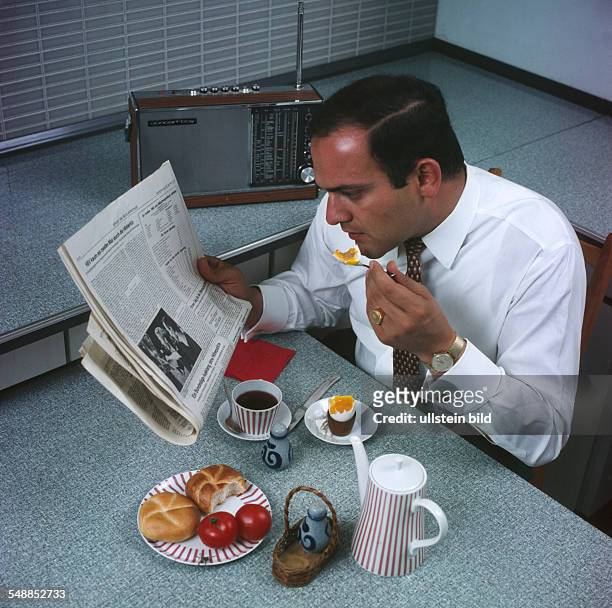 Man at the braekfast table is reading the newspaper - 1960s
