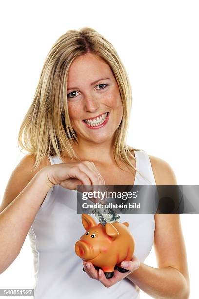 Symbolic photo saving money, woman putting dollar banknote into a piggy bank -