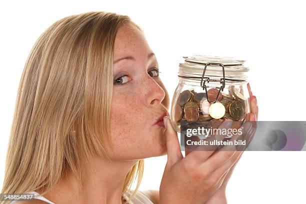 Symbolic photo saving money, woman kissing savings box -