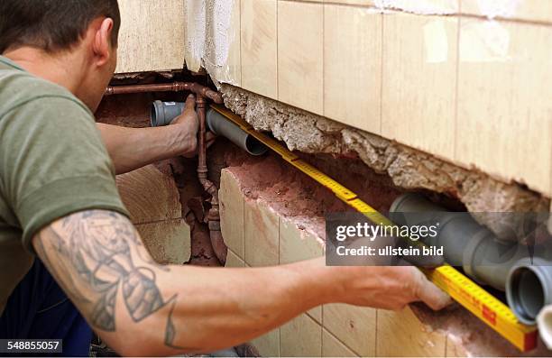 Installer installing a sewage pipe