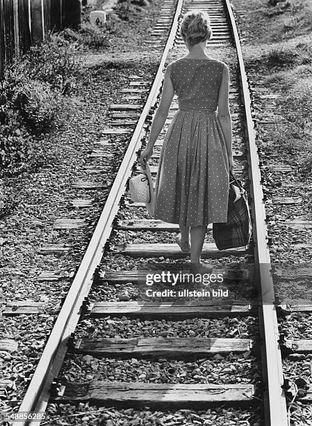 Germany - young woman is walking on railway tracks - 1950s