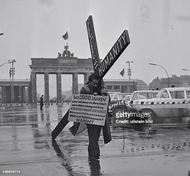 Germany Berlin - A Lebanese businessman carries a cross to the Brandenburg Gate in Berlin, protesting the inhumanity of mankind