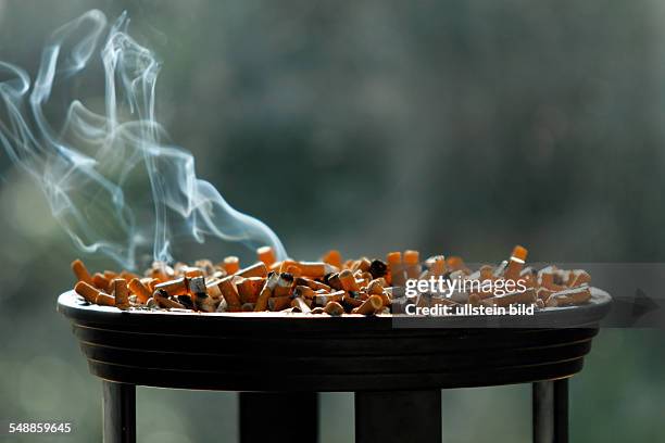 Big ashtray with smouldering butts