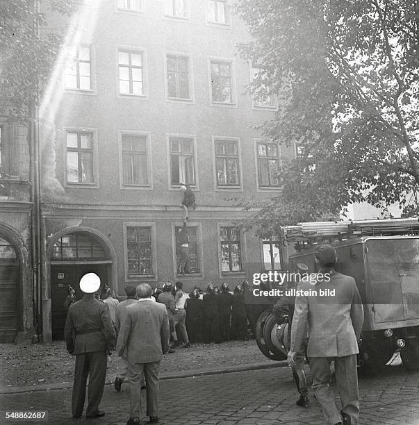 German Democratic Republic Bezirk Berlin East Berlin - The building of the wall. Frieda Schulze escaping out of the window of her flat in East-Berlin...