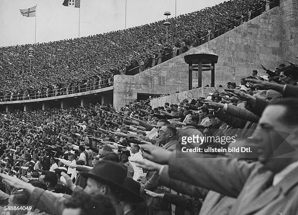 Sports, 1936 Olympics, Berlin: Crowded ranks in the Olympic stadium during a victory ceremony, in the middle is the fire bowl of the Olympic flame...