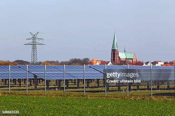 Germany Schleswig-Holstein Dithmarschen - solar plant on a field next to Meldorf, in the background the cathedral