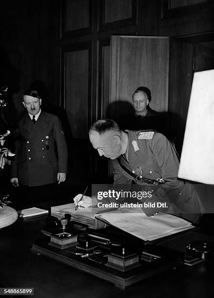 The romanian head of state Ion Antonescu in the 'Fuehrerbau' at the Koeniglicher Platz in Munich signing the guestbook; in the background from left:...