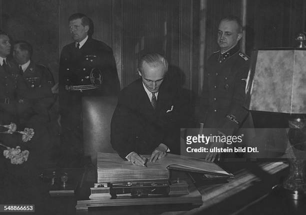 Foreign Minister Laszlo v. Bardossy signing the guest book of the 'Fuehrerbau' at the Koeniglicher Platz in Munich;in the background from left:...