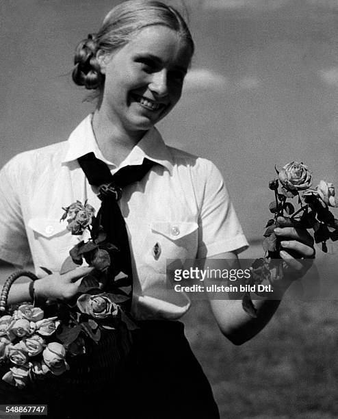 Germany : German 'Rosentag ': A young girl of the BDM selling roses for the benefit of the aid organization 'Mutter und Kind ' - Juni 1934 -...