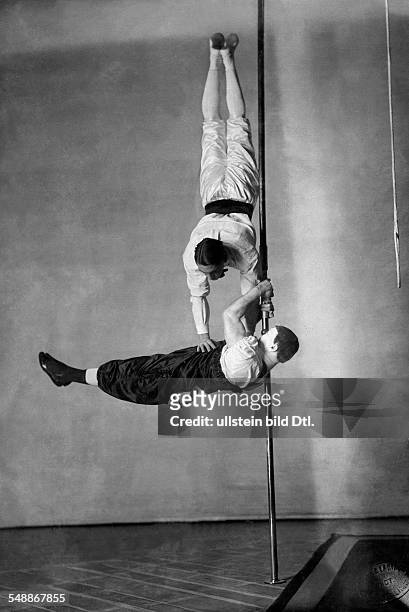 The Willuhn brothers performing an acrobatic act at the pole - undated - Photographer: Zander & Labisch - Published by: 'Berliner Illustrirte...