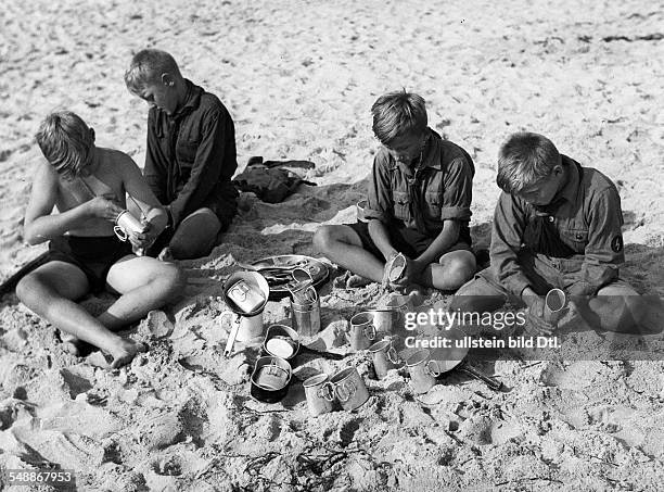 Summer camp of the Berliner Hitlerjugend at the Baltic Sea: Boy washing kitchenware with sand at the beach - ca. 1933 - Photographer: Argusphot...