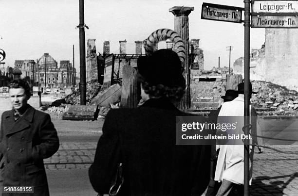 Federal Republic of Germany Berlin Berlin: Passersbys at the destroyed Leipziger Platz with street signs in German and Russian script; in the...