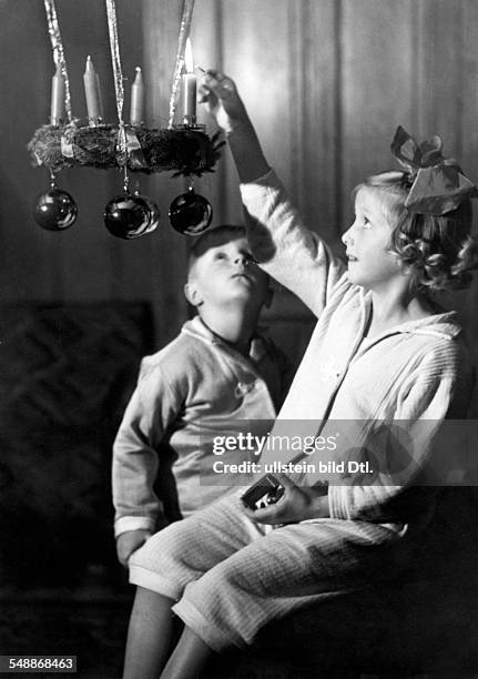 Children lighting the first candle on a Advent wreath - 1938 - Photographer: Weltbild - Published by: 'Das 12 Uhr Blatt' Vintage property of ullstein...