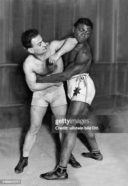 Boxing: two boxers demonstrate what is not allowed in boxing - using the ellbow to punch / clinching - 1921 - Photographer: Alfred Gross - Published...