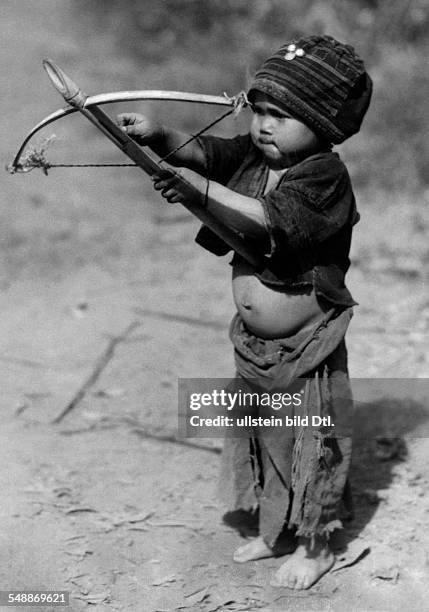 The former state Siam : A four year old small Siam - boy with bow and arrow as an archer - ca. 1937 - Photographer: Hugo Adolf Bernatzik - Published...