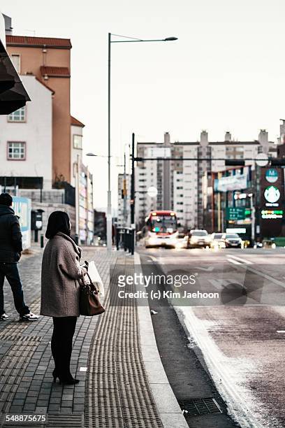 woman waiting for bus - auto von hinten winter stock-fotos und bilder