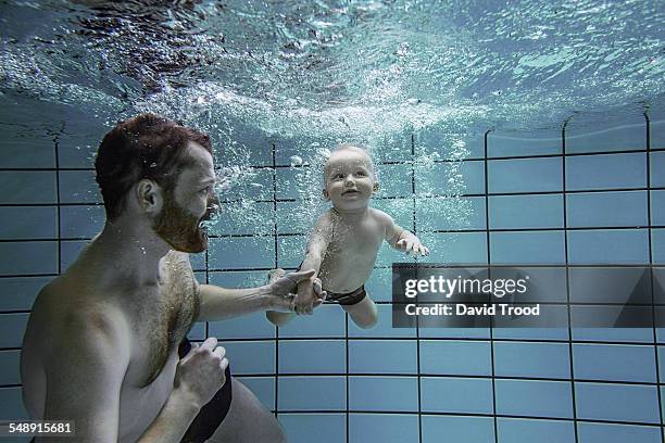 child learning to swim. - baby swimmer stock-fotos und bilder